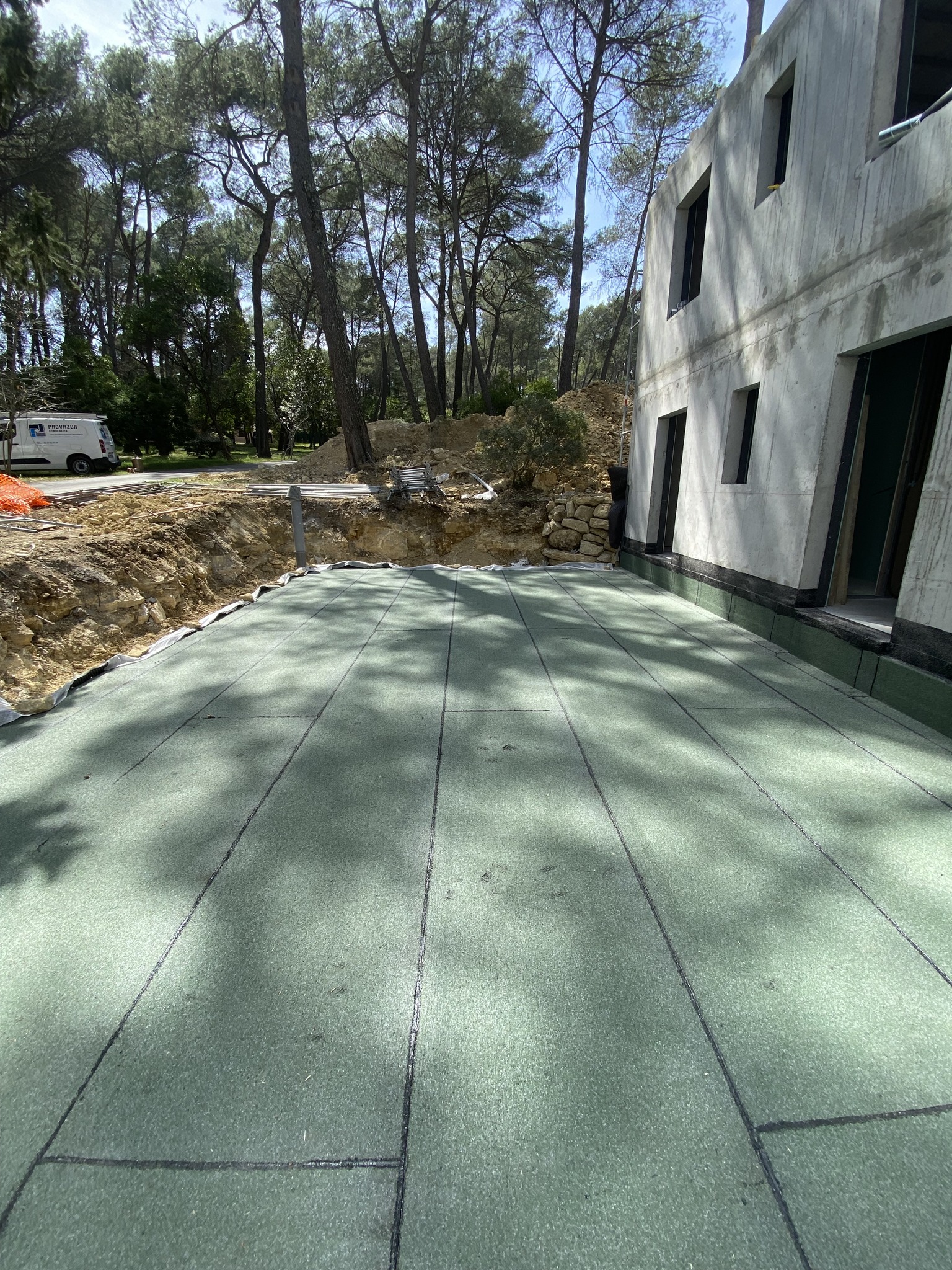 Travaux d'étanchéité sur terrasse devant un bâtiment